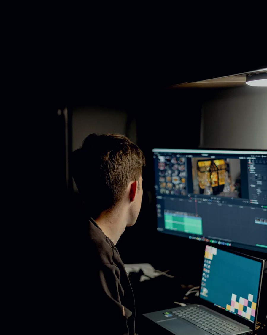 A video editor working across two screens